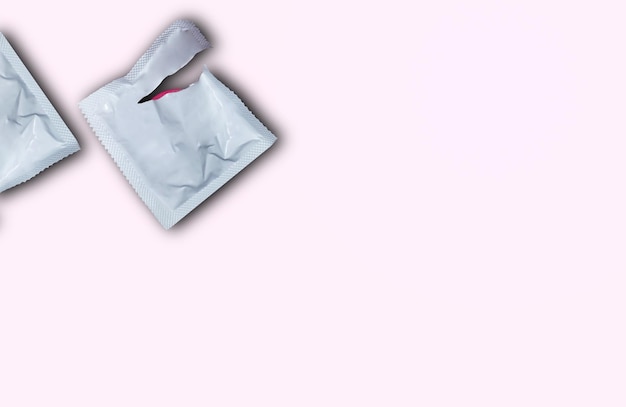 Photo condom on pink background flat view from above the concept of safe sex