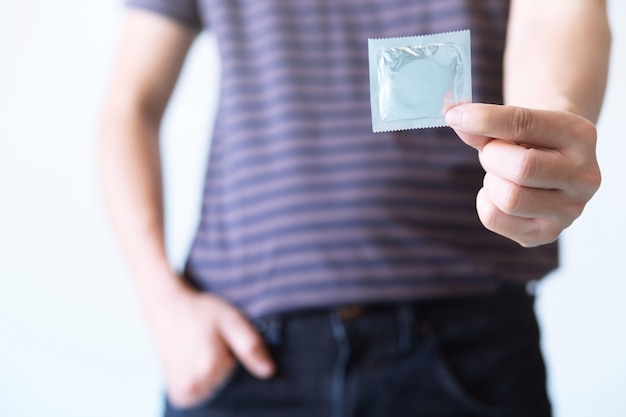 Condom ready to use in male hand, contraceptives control the birth rate or safe prophylactic. World AIDS Day