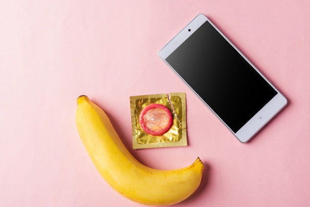 Foto preservativo in confezione wrapper e schermo vuoto del telefono cellulare intelligente