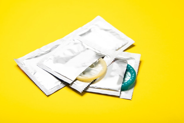 Фото Презервативы в пакетах на желтом фоне