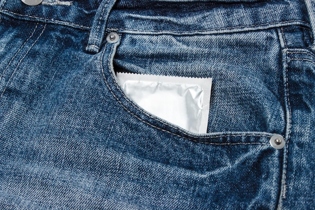 安全なセックスのためにジーンズのポケットにコンドームを入れる