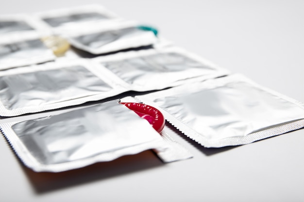 Condoms in packages on white background