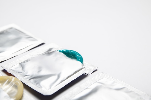 Condoms in packages on white background