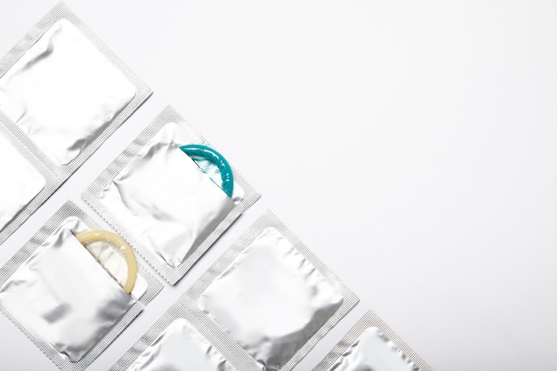 Condoms in packages on white background