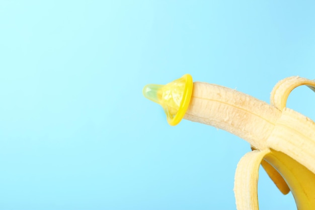 Condoom op banaan tegen kleurachtergrond Veilig seksconcept