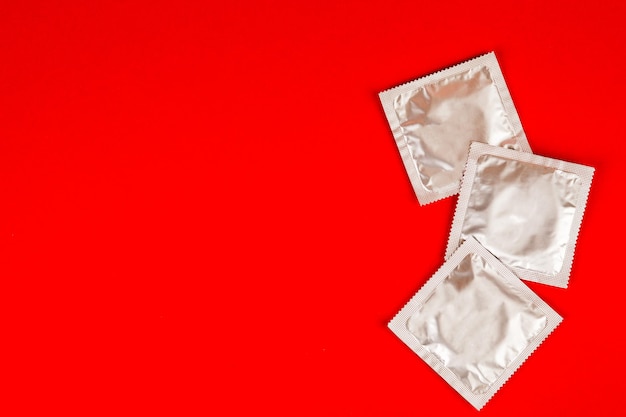 Condoom op rode achtergrond Veilige seks concept