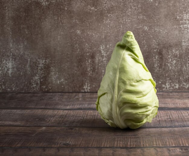 Cone head cabbage for dietary vegan on a brown background