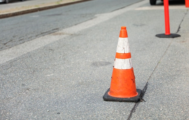 A cone that has been bent over in the middle of the street.