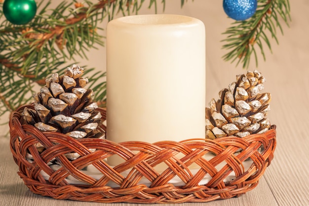 Cones candle and natural fir tree branches with Christmas ornament