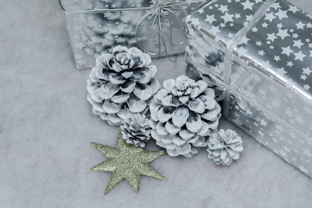 Шишки в снегу и подарки в серебряной упаковке