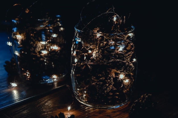 Шишки с гирляндой в стеклянной вазе рождество рождество праздник новый год зимний свет праздничные украшения