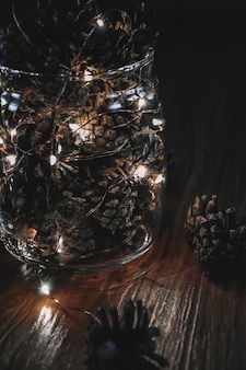 Coni con ghirlanda in vaso di vetro natale vacanze natale capodanno inverno luce decorazioni festive