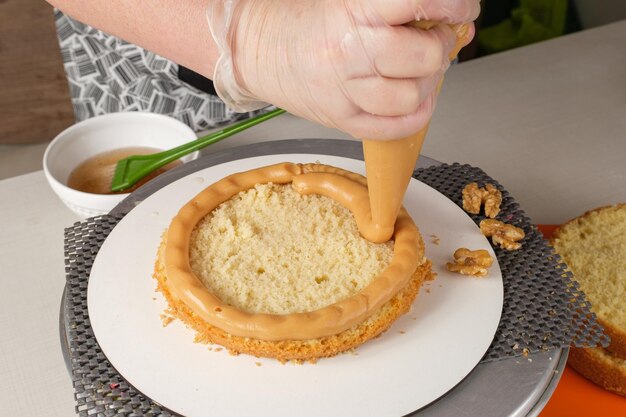 Confectioner filling cake with dulce de leche brigadeiro.