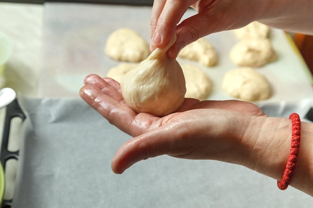 Confectioner forms buns with cherries from baking dough