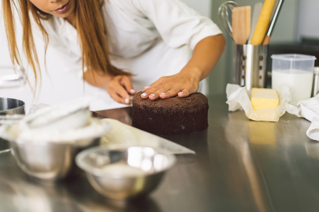 Foto la pasticcera sta preparando un biscotto con crema bianca e torte da cucina al cioccolato