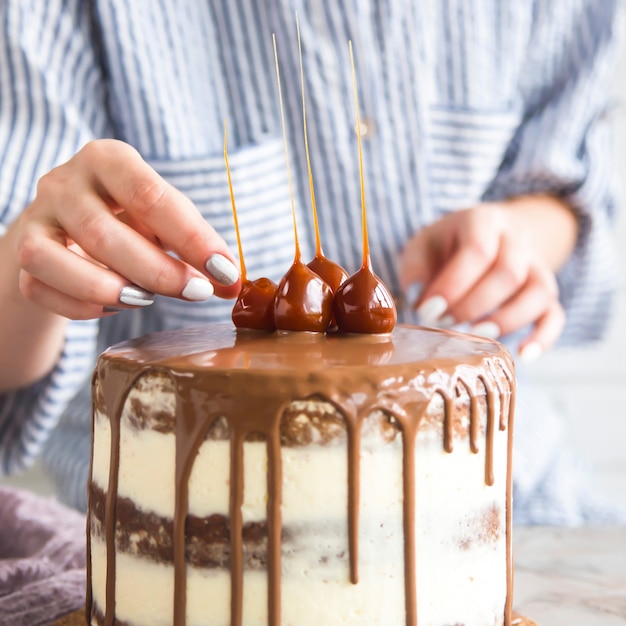 Un pasticcere sta decorando una torta già pronta