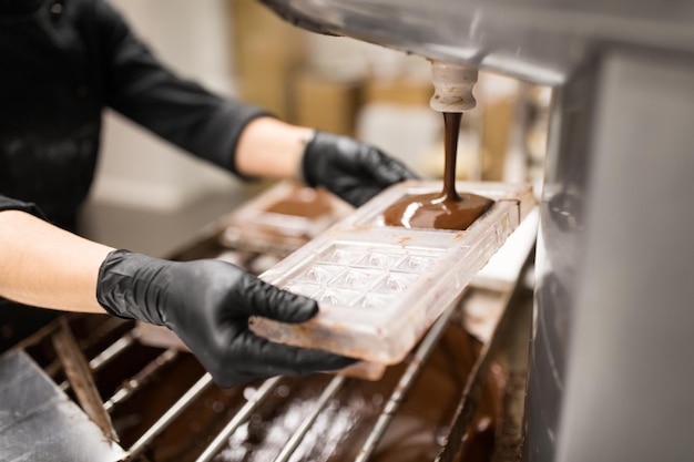 Photo confectioner makes chocolate candies at sweetshop
