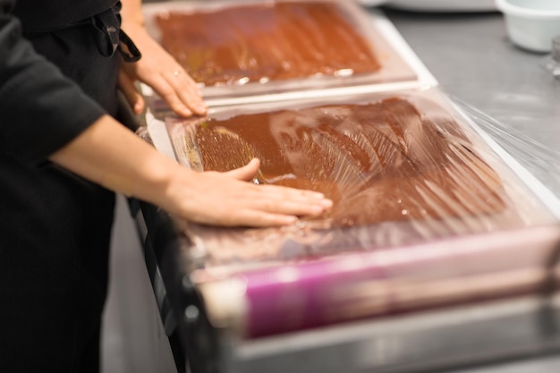 confectioner makes chocolate dessert at sweetshop