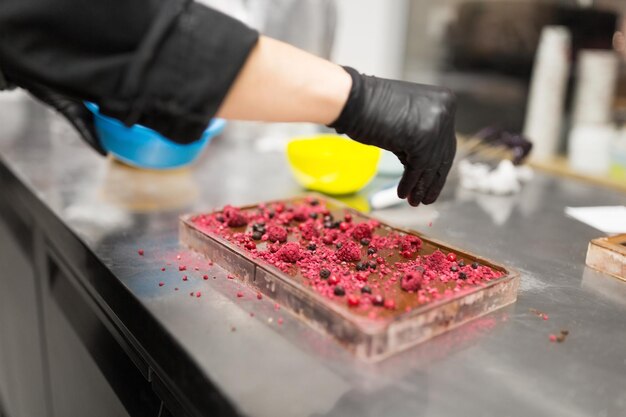 Photo confectioner makes chocolate dessert at sweetshop