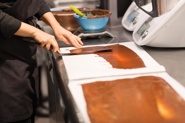 Photo confectioner makes chocolate dessert at sweetshop