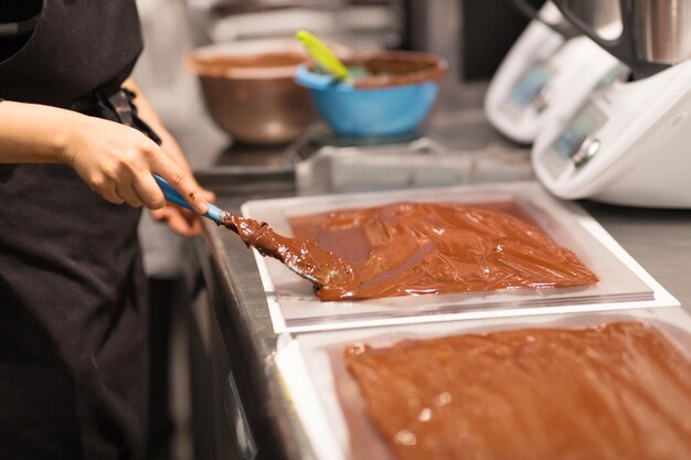 Photo confectioner makes chocolate dessert at sweetshop