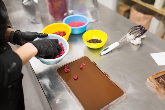 Photo confectioner makes chocolate dessert at sweetshop