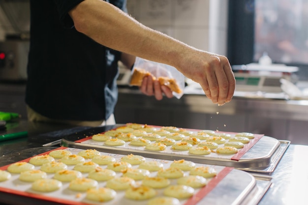 A confectioner makes macaroons in a pastry shop