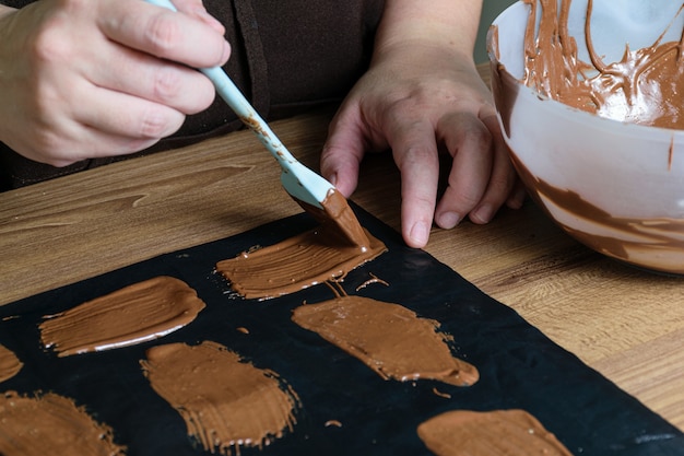 Confectioner making chocolate plates, decorative piece for a cake.