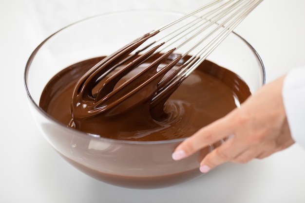 Confectioner mixing melted premium dark chocolate