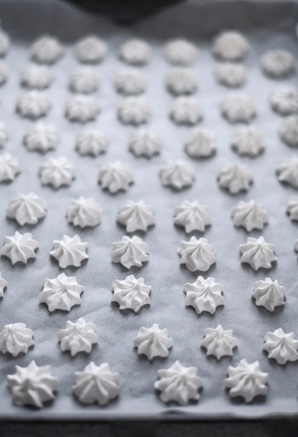 Confectioner prepares meringue in the kitchen. meringue on a baking sheet.