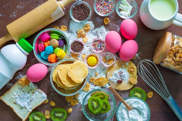 Attrezzatura per pasticceria e torte ciotole con gli ingredienti necessari per cuocere cupcakes colorati