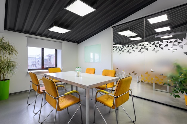 A conference room with orange chairs and a white board on the wall in it office meeting workspace