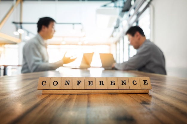 Conference word on wood table with Business team work discussion together concept in background.