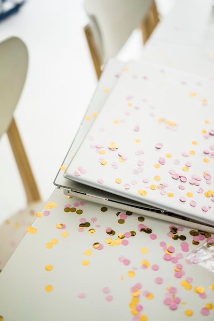 Confetti on desk with laptop in office