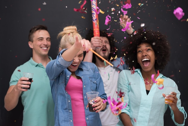 confetti party Multiethnics groep gelukkige jonge mensen die oudejaarsavond vieren terwijl ze dansen en thuis plezier hebben