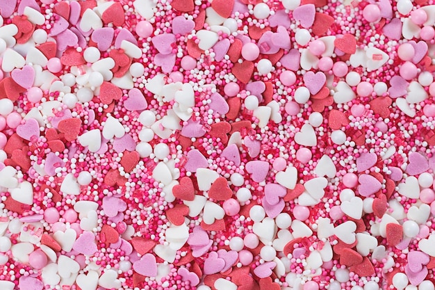 Foto confetti snoepjes achtergrond in roze tinten. valentijnsdag achtergrond