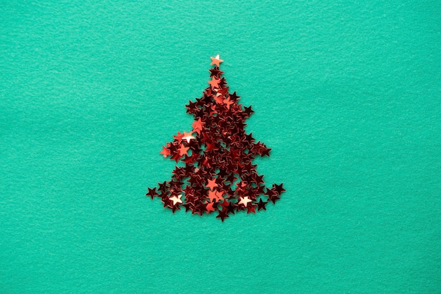 Confetti stars are stacked in the shape of a Christmas tree christmas composition