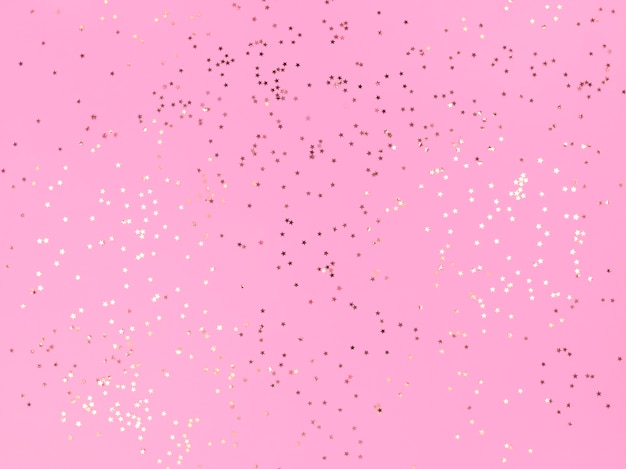 Stelle di coriandoli scintillanti su uno sfondo rosa.