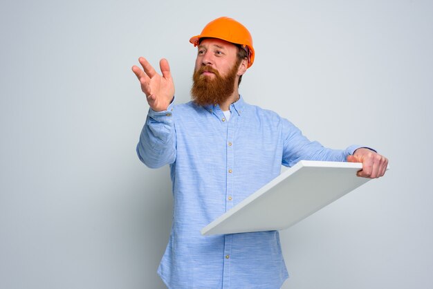 Confidant architect with beard and orange helmet does a sketch