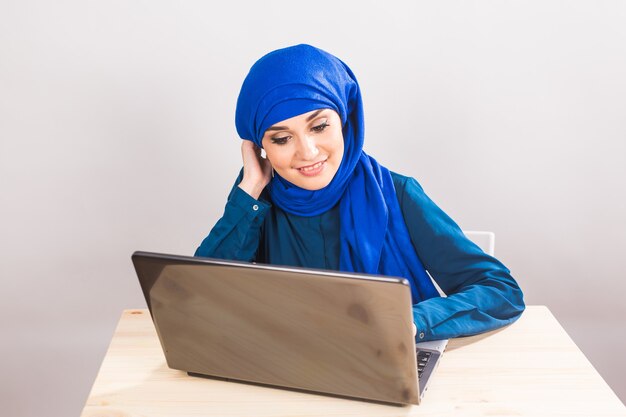 自信のかなりイスラム教徒の女性はラップトップで動作します。ビジネスと金融の概念。