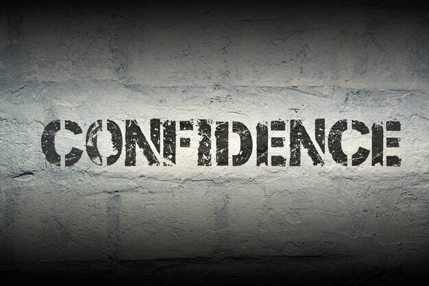 Confidence stencil print on the grunge white brick wall