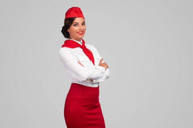 Confident adult air hostess in colorful uniform