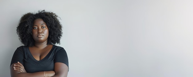 Confident African American woman with crossed arms on a light background