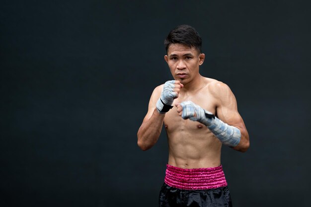 Photo confident asian boxer athlete man shirtless preparing to fight in stadium