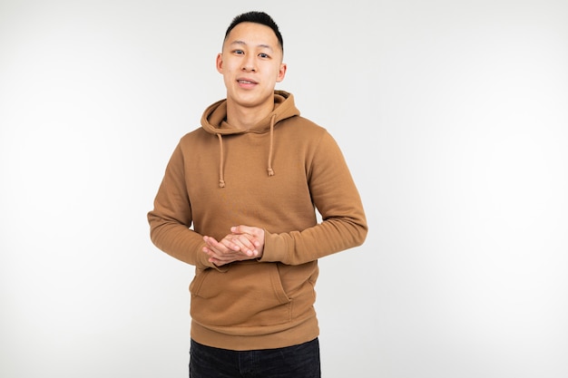 Confident asian man in brown hoodie on white