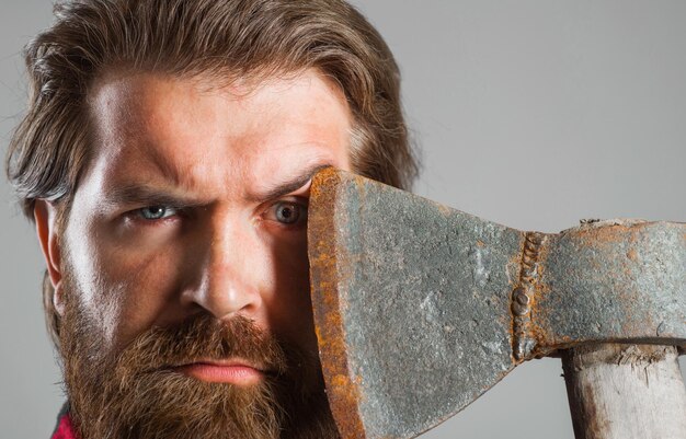 Confident bearded man with axe near face serious lumberjack sharp blade male with ax closeup