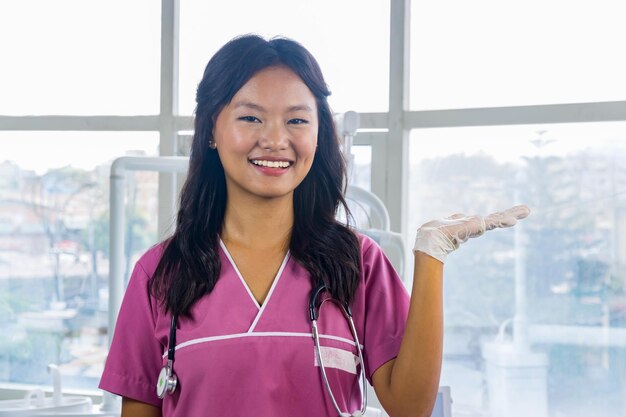 Foto fiducioso bellissimo indiano dall'aspetto nepalese dentista dottoressa ragazza sorridente e dando gesti