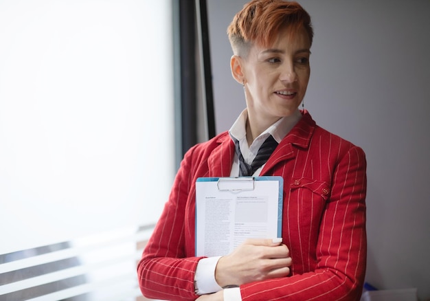 confident beautiful smart redhaired business woman or manager standing in modern office
