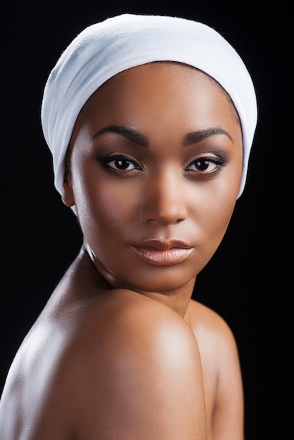 자신감 있는 아름다움. 머리 스카프를 착용하고 카메라를 보고 있는 아름다운 아프리카 여성