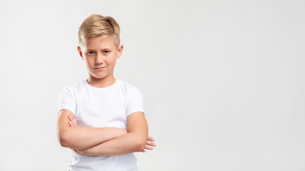 Ritratto di ragazzo sicuro. stile di vita del bambino. bambino biondo arrogante in piedi con le braccia incrociate isolato sullo spazio bianco della copia.